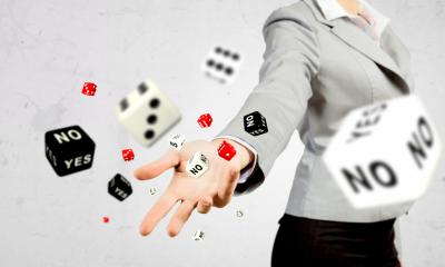 Businesswoman throwing a hand full of dice up in the air