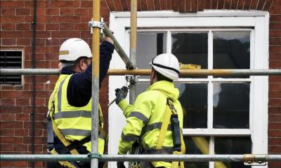 Scaffolders in high visibility jackets  working by a window 